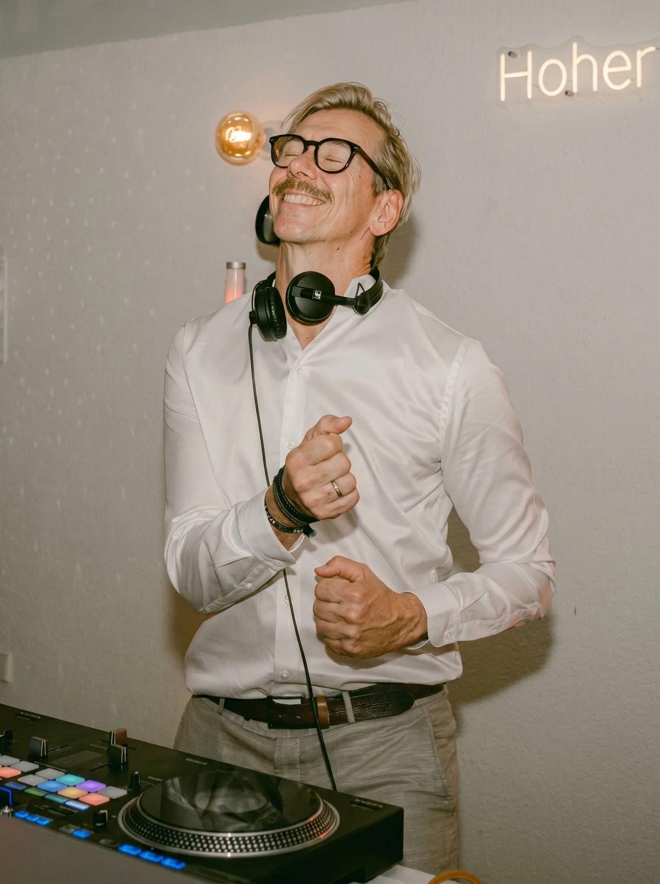 Alex Maus mit Kopfhörern hinter dem DJ-Pult, in Aktion